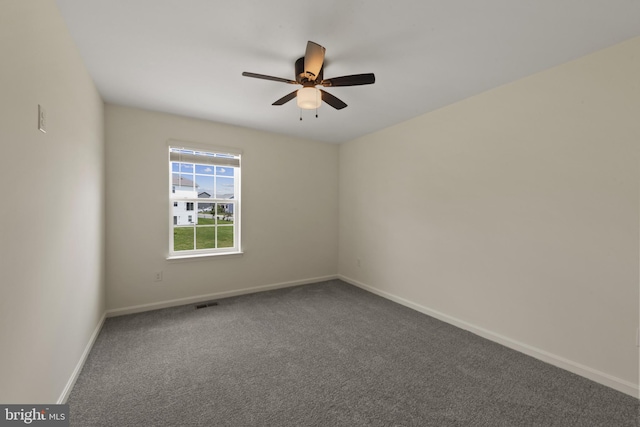 carpeted empty room featuring baseboards and a ceiling fan