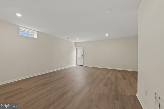 empty room featuring baseboards, wood finished floors, and recessed lighting