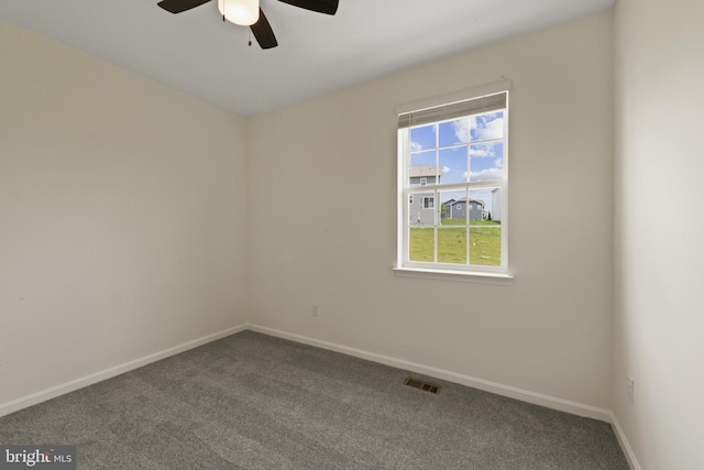 carpeted spare room with ceiling fan and baseboards