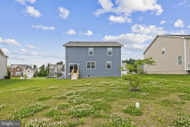 back of house with a yard, entry steps, and a residential view
