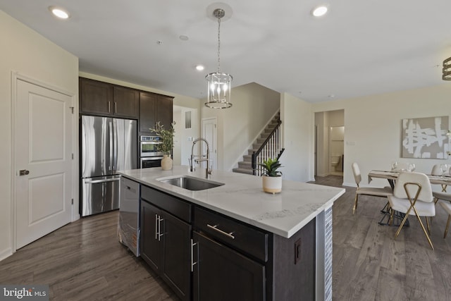 kitchen with stainless steel appliances, a sink, hanging light fixtures, recessed lighting, and a kitchen island with sink