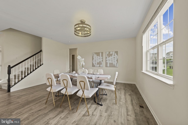 dining room with stairs, wood finished floors, and baseboards