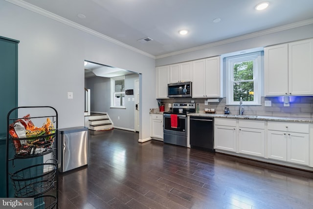 10560 S Faulkner Rd, Faulkner, MD 20632 - kitchen with stainless steel appliances, a sink, decorative backsplash, white cabinetry, and ornamental molding