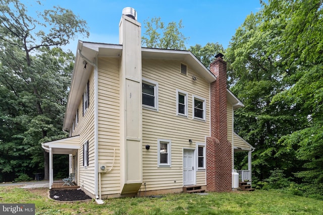 10560 S Faulkner Rd, Faulkner, MD 20632 - rear view of property featuring a chimney, a lawn, and entry steps