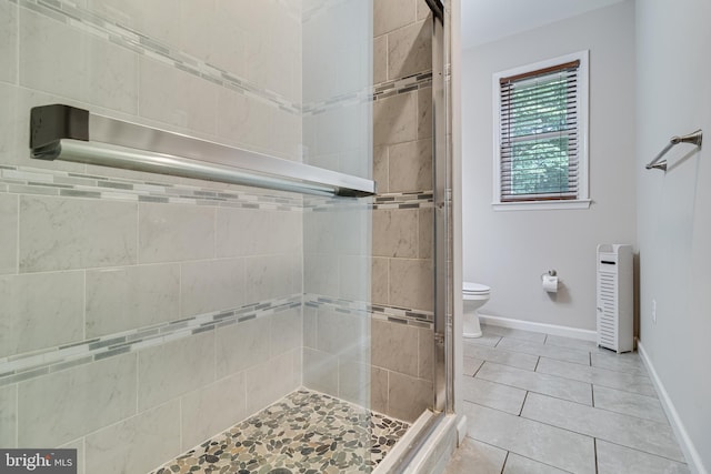 10560 S Faulkner Rd, Faulkner, MD 20632 - full bathroom featuring a shower stall, tile patterned flooring, toilet, baseboards, and heating unit