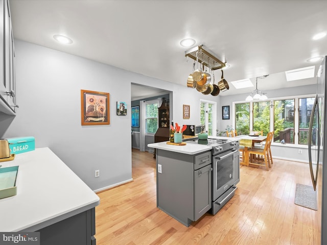 5264 Open Window, Columbia, MD 21044 - kitchen with stainless steel appliances, gray cabinets, light countertops, light wood-style flooring, and a kitchen island