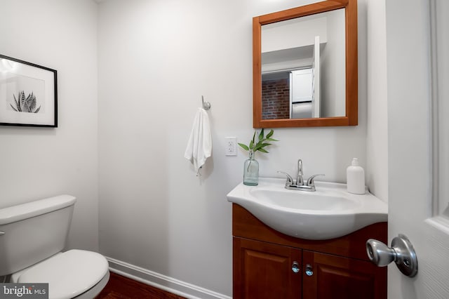 214 S Madeira St S, Baltimore, MD 21231 - half bathroom featuring vanity, toilet, wood finished floors, and baseboards