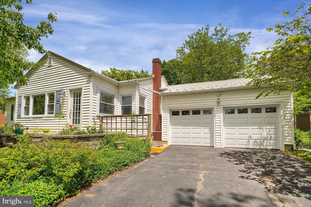 934 Houserville Rd, State College, PA 16801 - ranch-style house with asphalt driveway, a garage, a chimney, and metal roof