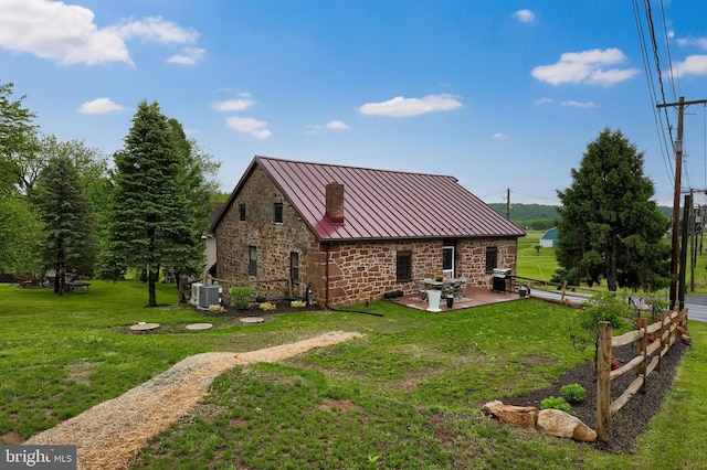 1700 N Texter Mountain Rd, Reinholds, PA 17569 - rear view of property with a standing seam roof, stone siding, a patio, and a lawn