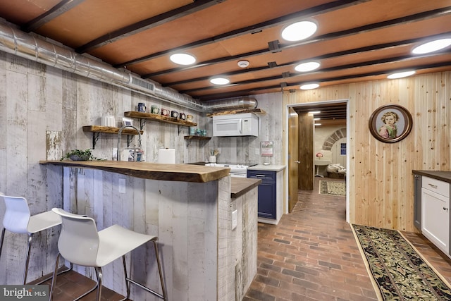 1700 N Texter Mountain Rd, Reinholds, PA 17569 - kitchen featuring white appliances, brick floors, open shelves, wood counters, and a breakfast bar