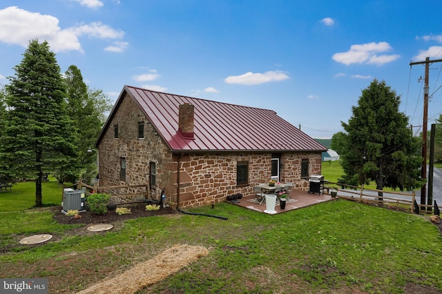 1700 N Texter Mountain Rd, Reinholds, PA 17569 - rear view of house featuring a standing seam roof, metal roof, stone siding, a patio, and central air condition unit