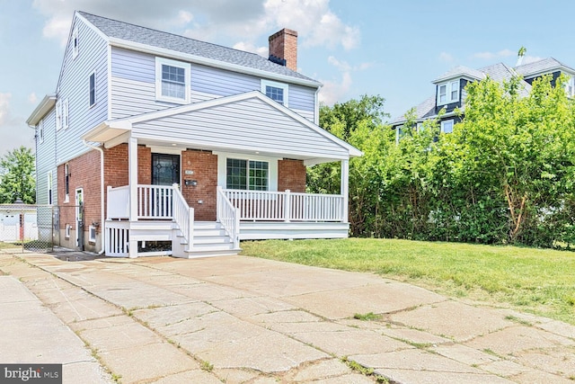 3604 White Ave, Baltimore, MD 21206 - view of front facade with a chimney, brick siding, covered porch, and a front lawn