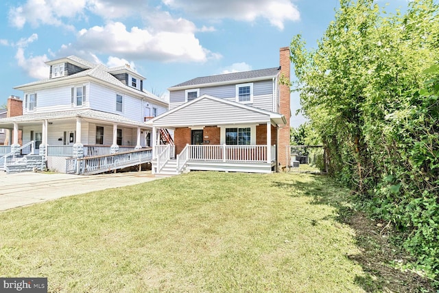3604 White Ave, Baltimore, MD 21206 - view of front facade with a porch, a chimney, brick siding, and a front lawn