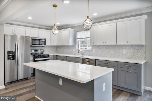 3604 White Ave, Baltimore, MD 21206 - kitchen featuring appliances with stainless steel finishes, a sink, gray cabinets, ornamental molding, and dark wood-type flooring