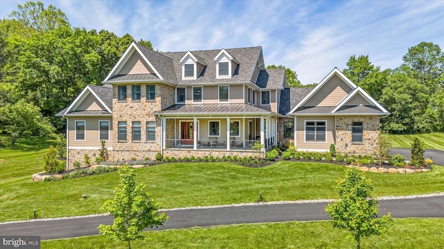 5 Raintree Rd, Chadds Ford, PA 19317 - view of front facade featuring covered porch, stone siding, a standing seam roof, a front yard, and metal roof