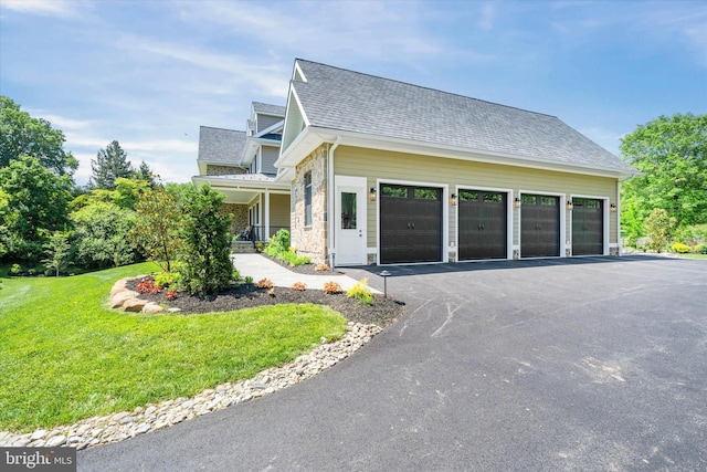 5 Raintree Rd, Chadds Ford, PA 19317 - view of front facade with a front yard, a shingled roof, asphalt driveway, and stone siding