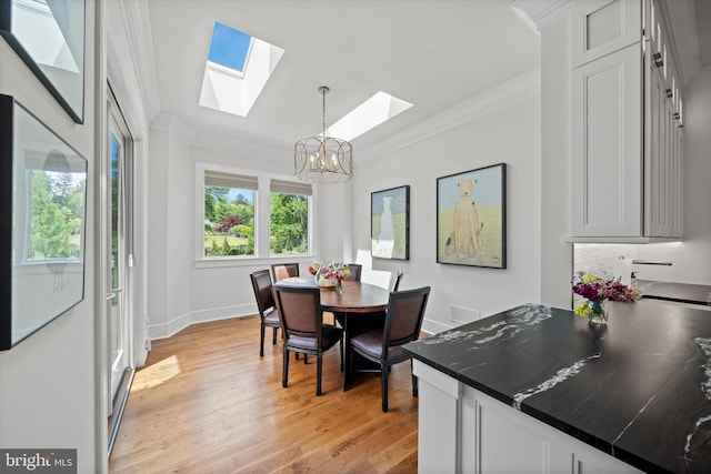 5 Raintree Rd, Chadds Ford, PA 19317 - dining area featuring a chandelier, a skylight, ornamental molding, baseboards, and light wood-type flooring