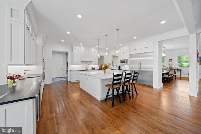 5 Raintree Rd, Chadds Ford, PA 19317 - kitchen featuring stainless steel appliances, white cabinets, dark wood-style floors, a large island, and a kitchen breakfast bar