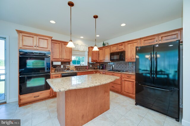 314 Valley Ct, Sinking Spring, PA 19608 - kitchen with black appliances, light stone counters, a center island, backsplash, and decorative light fixtures