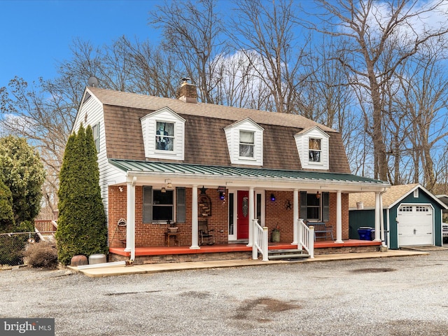 dutch colonial featuring a gambrel roof, brick siding, and covered porch