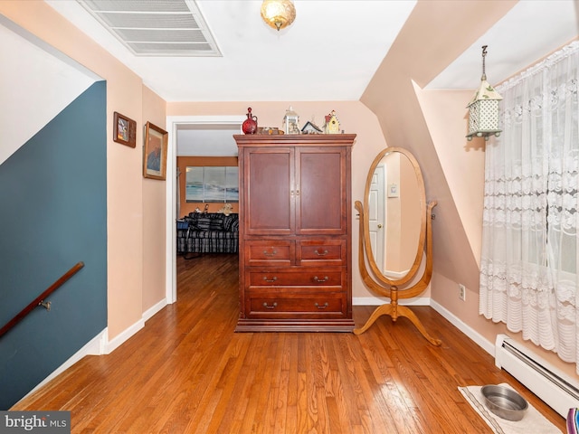 entryway with a baseboard radiator, light wood-style floors, and baseboards
