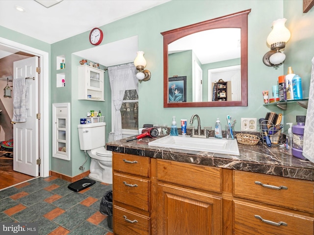 bathroom with vanity, baseboards, and toilet