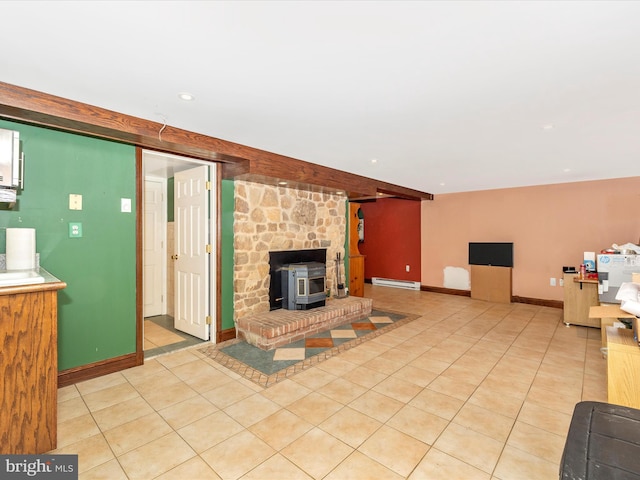 living area with a wood stove, a baseboard radiator, baseboards, and light tile patterned floors