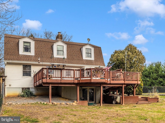 rear view of house featuring a deck, roof with shingles, and a chimney