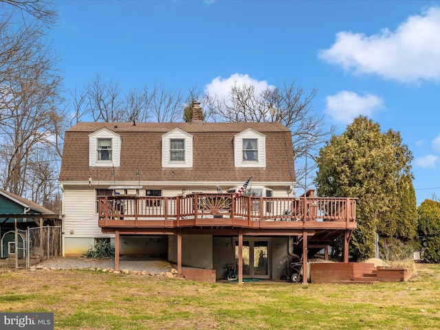 rear view of house featuring a wooden deck, roof with shingles, and a chimney
