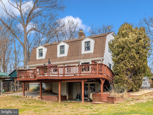 rear view of house featuring roof with shingles, a wooden deck, and a chimney