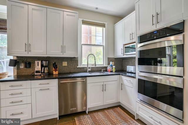 3707 Thornapple St, Chevy Chase, MD 20815 - kitchen featuring stainless steel appliances, a sink, decorative backsplash, and dark stone counters