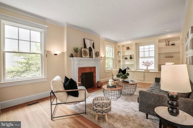 3707 Thornapple St, Chevy Chase, MD 20815 - living area featuring light wood-style floors, baseboards, a fireplace with flush hearth, and ornamental molding