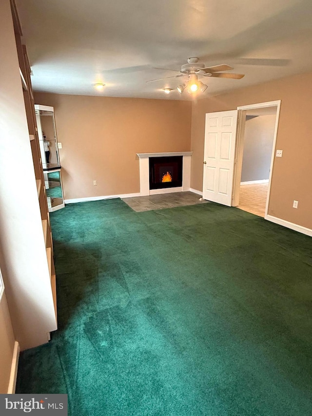 821 W Potomac St, Brunswick, MD 21716 - unfurnished living room featuring a ceiling fan, dark carpet, a fireplace with flush hearth, and baseboards