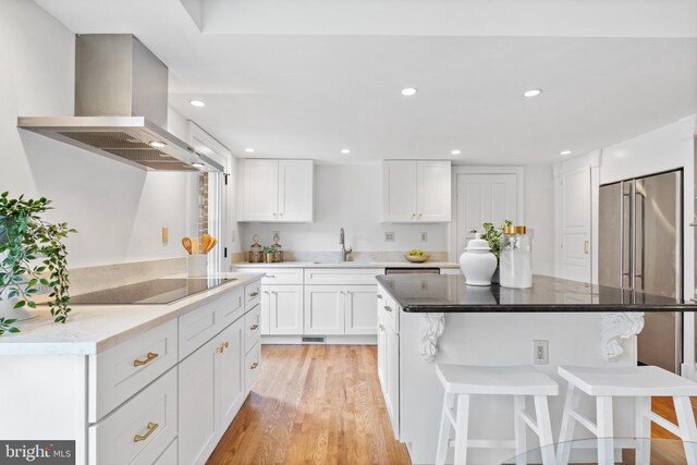 710 Belgrove Rd, Mclean, VA 22101 - kitchen featuring extractor fan, a kitchen breakfast bar, black electric stovetop, a sink, and white cabinets