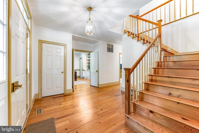 16909 Batchellors Forest Rd, Silver Spring, MD 20906 - foyer entrance with stairway, light wood-type flooring, baseboards, and a chandelier