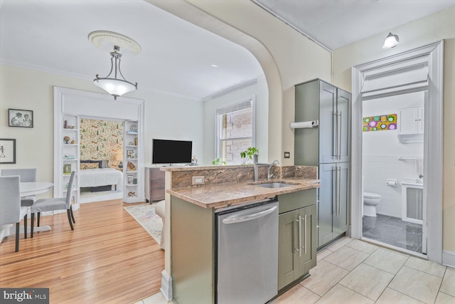 kitchen featuring a sink, dishwasher, open floor plan, crown molding, and a peninsula