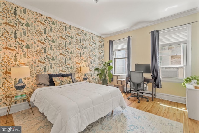 bedroom featuring crown molding, hardwood / wood-style floors, baseboards, wallpapered walls, and cooling unit