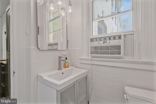 bathroom featuring tile walls, toilet, vanity, and cooling unit