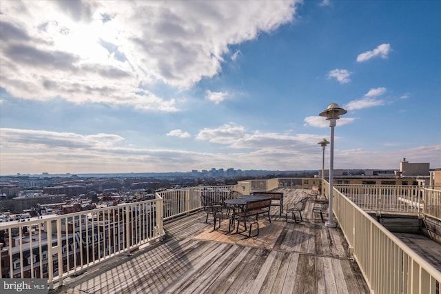 wooden terrace with outdoor dining space and a view of city