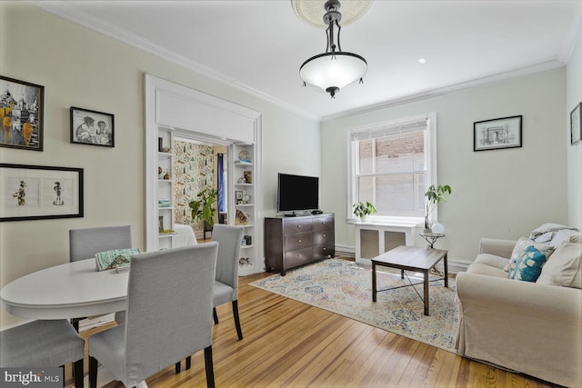 living room featuring ornamental molding, light wood-type flooring, and baseboards