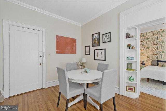 dining room with light wood-style floors, ornamental molding, and baseboards