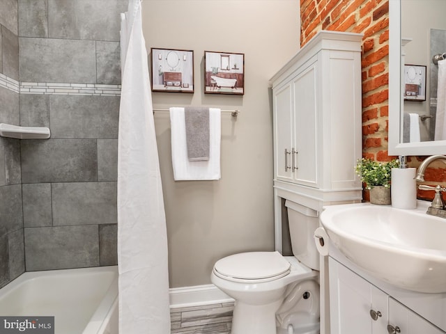 628 E Fort Ave, Baltimore, MD 21230 - bathroom with vanity, baseboards, toilet, and brick wall