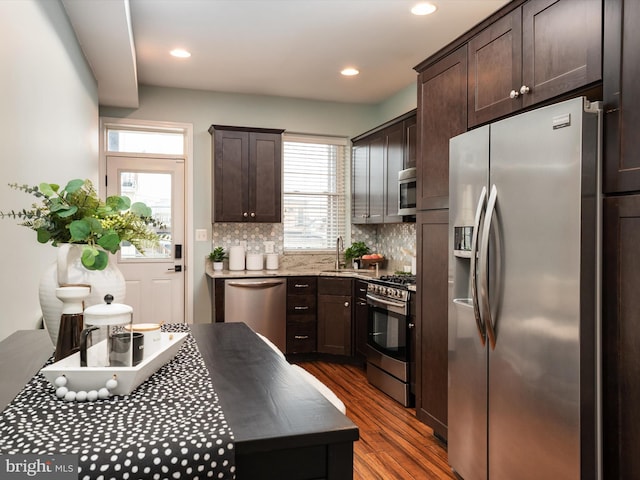 628 E Fort Ave, Baltimore, MD 21230 - kitchen with stainless steel appliances, dark brown cabinetry, dark wood-style floors, a sink, and tasteful backsplash