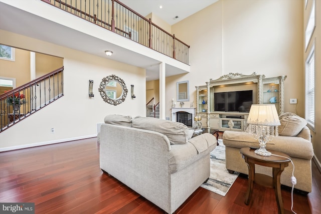 15613 Ancient Oak, North Potomac, MD 20878 - living area featuring a towering ceiling, a glass covered fireplace, stairs, and dark wood finished floors