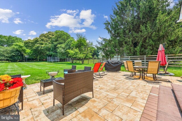 15613 Ancient Oak, North Potomac, MD 20878 - fenced backyard with a trampoline, outdoor dining area, a patio area, a grill, and view of wooded area