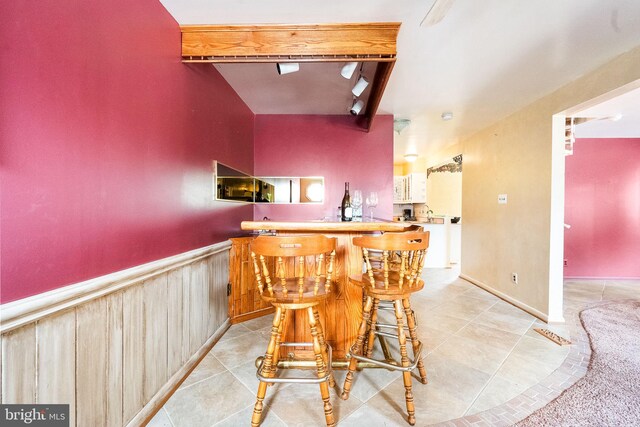1213 Terrylynn Ct, Herndon, VA 20170 - indoor bar with beamed ceiling, light tile patterned floors, and a wainscoted wall