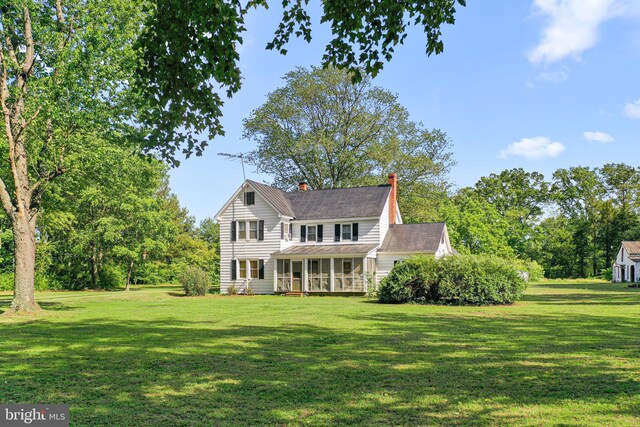 1838 Muddy Gut Rd, Dunnsville, VA 22454 - traditional-style home featuring a sunroom, a front yard, and a chimney