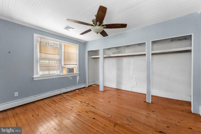 1838 Muddy Gut Rd, Dunnsville, VA 22454 - unfurnished bedroom featuring multiple closets, a baseboard radiator, baseboards, and hardwood / wood-style flooring