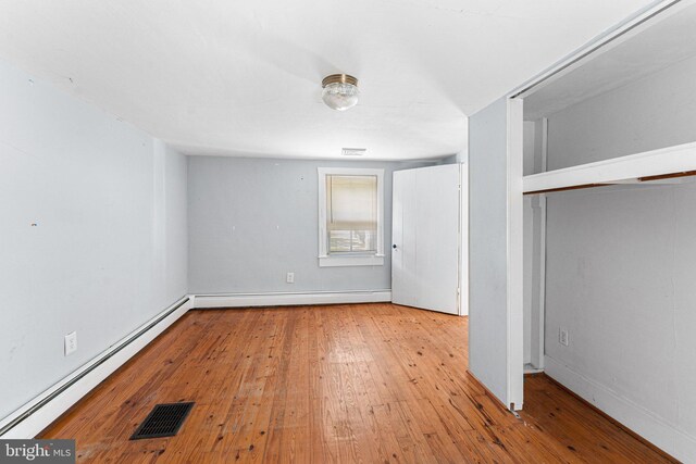 1838 Muddy Gut Rd, Dunnsville, VA 22454 - unfurnished bedroom with baseboard heating, hardwood / wood-style flooring, baseboards, and a closet