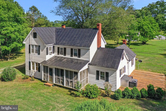 1838 Muddy Gut Rd, Dunnsville, VA 22454 - rear view of property with a sunroom, a chimney, a yard, and metal roof